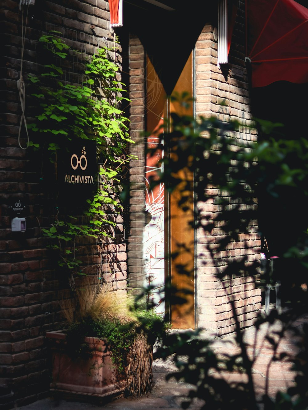 a brick building with a red umbrella and a sign on it