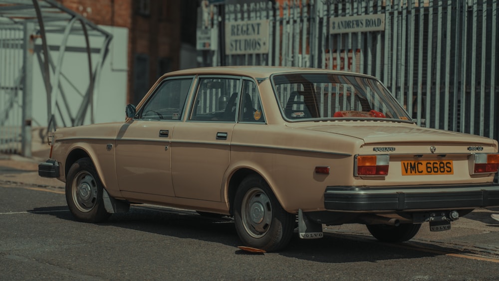 a tan car parked on the side of the road