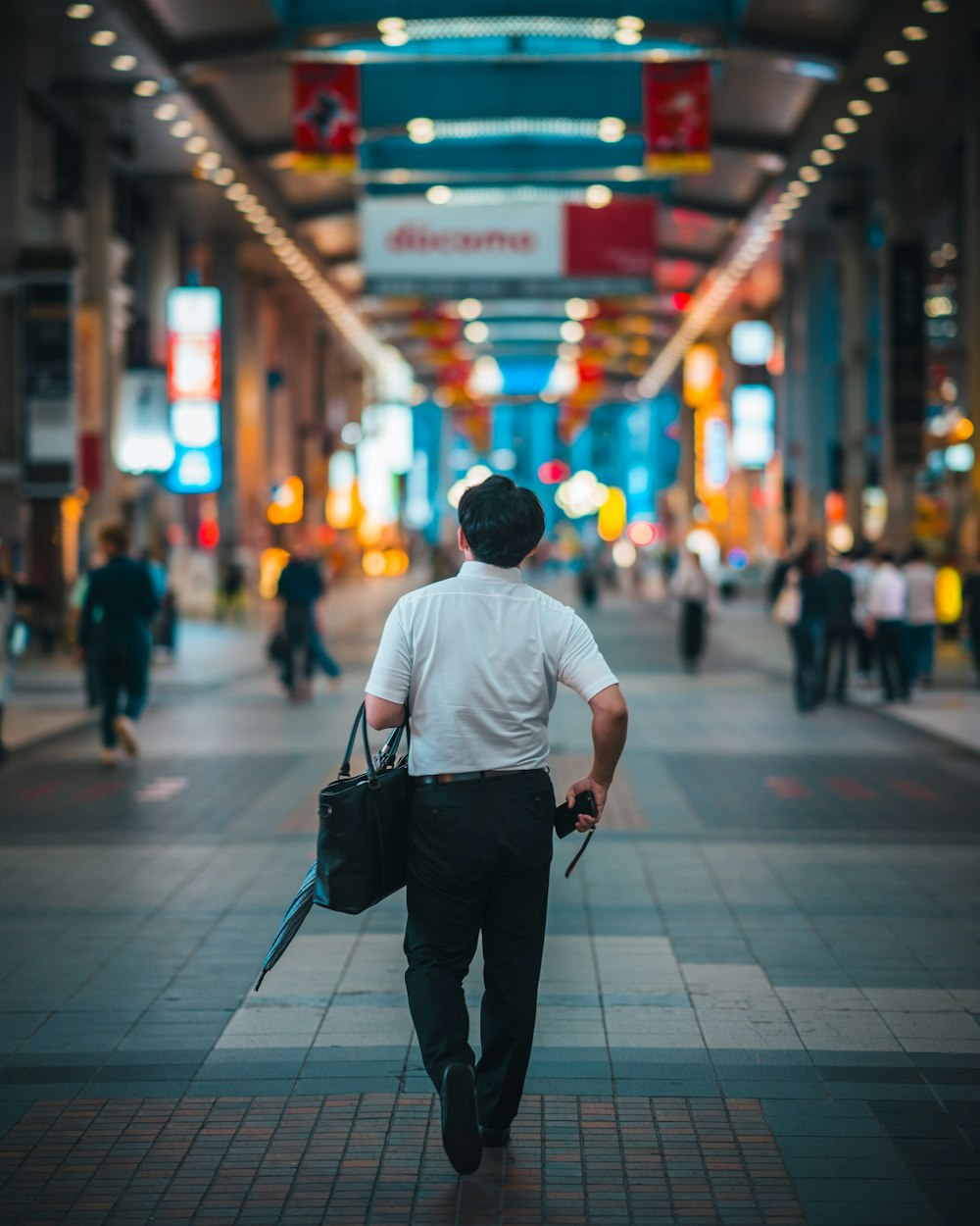 a man walking down a street carrying a briefcase