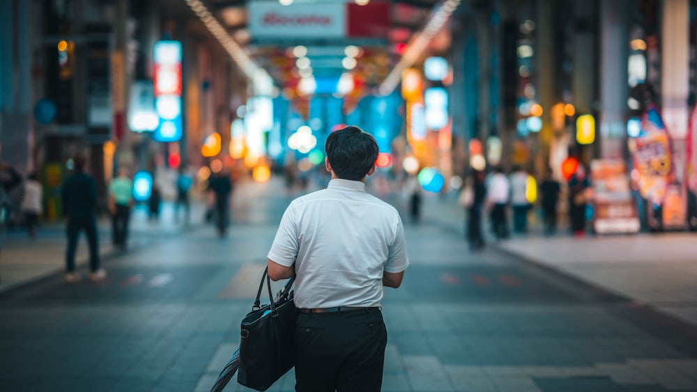 a man walking down a street holding a suitcase