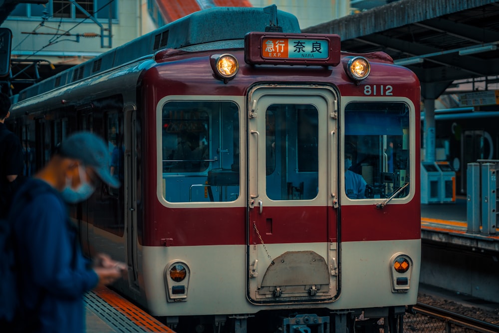 a red and white train pulling into a train station