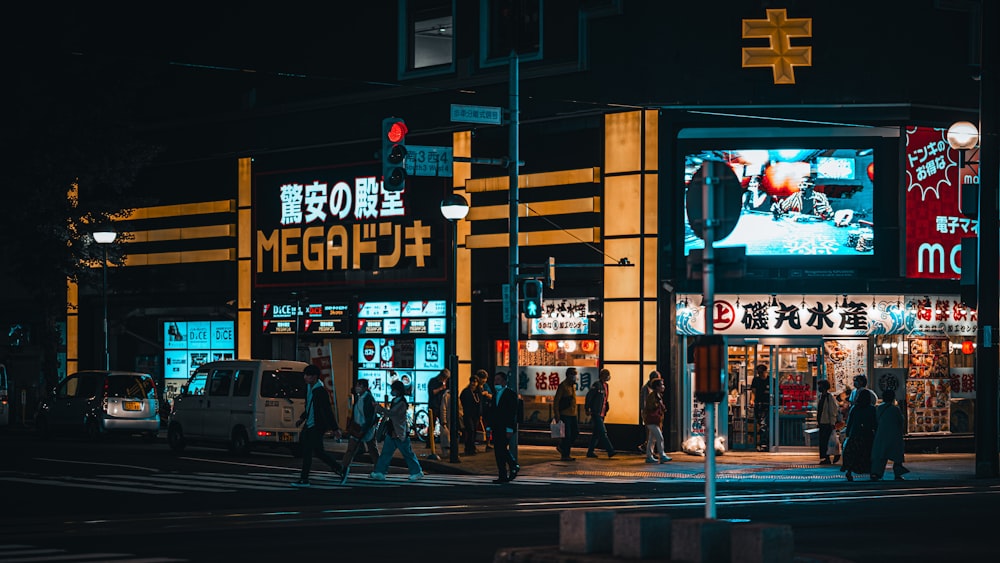 a group of people walking down a street at night