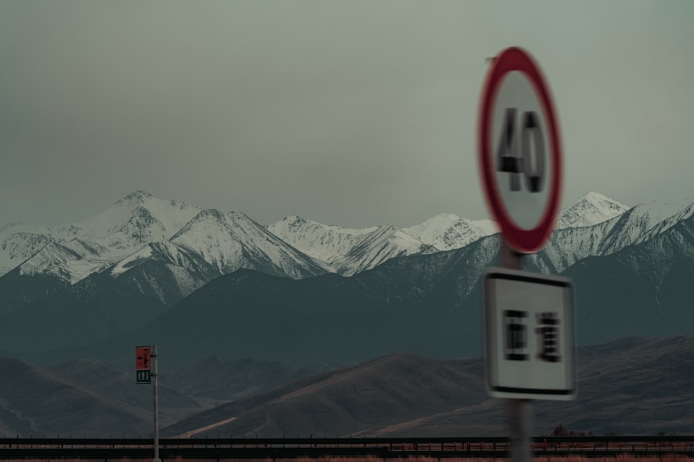 a road sign in front of a mountain range