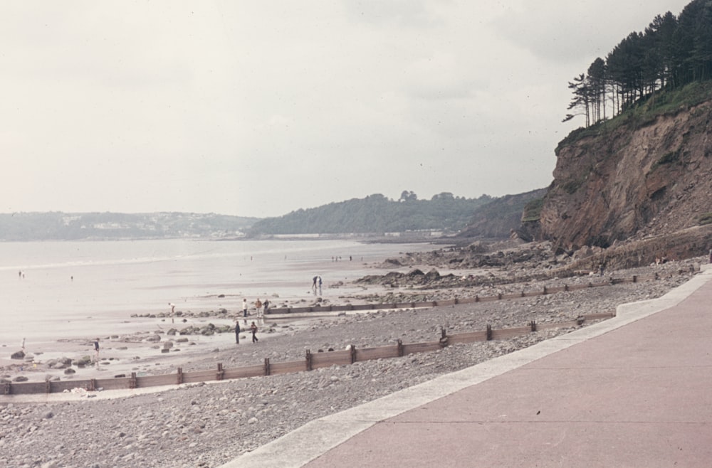 a man riding a skateboard down a sidewalk next to a beach