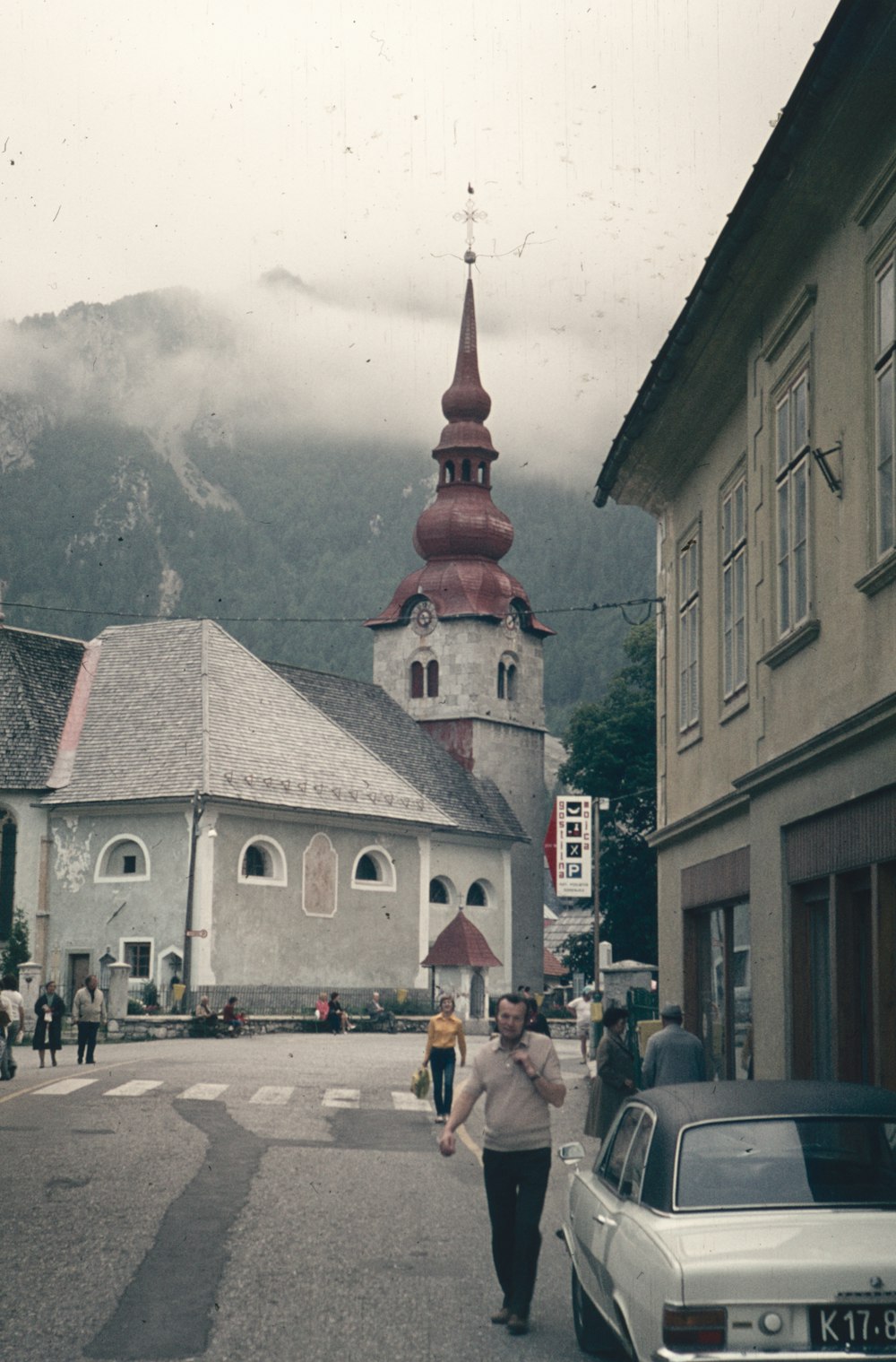 a woman walking down a street in front of a church