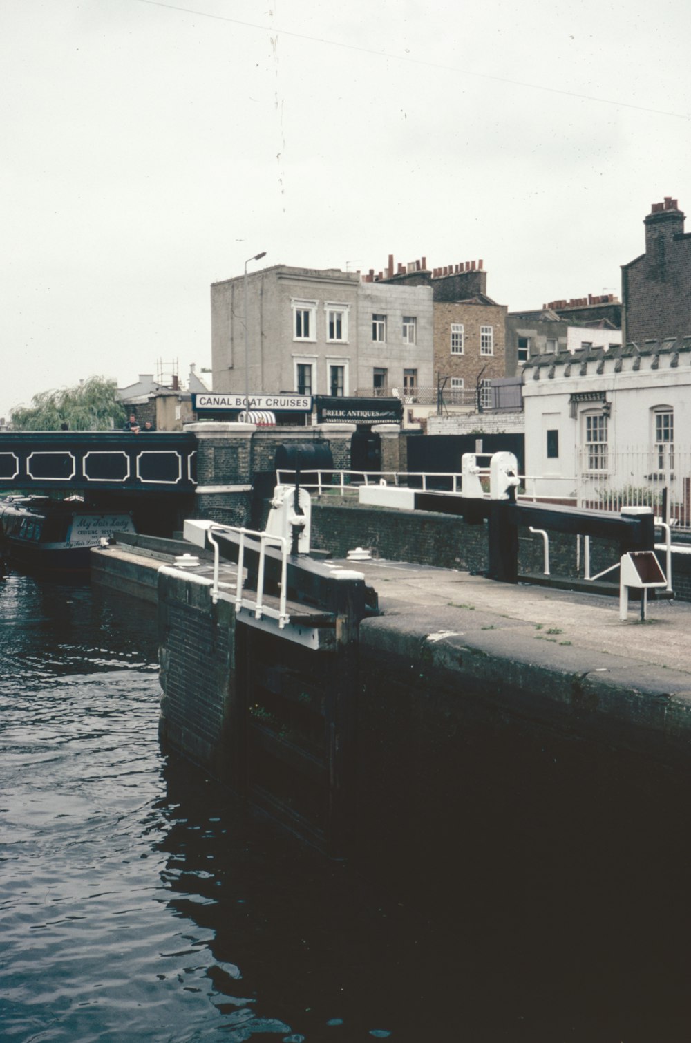 a river with a bridge and buildings in the background