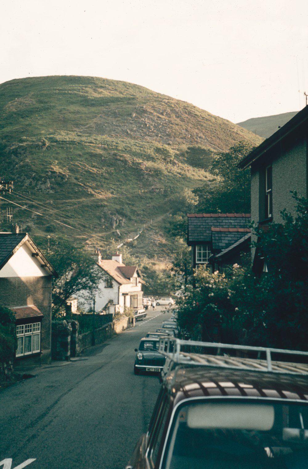 a car parked on the side of a road next to a hill