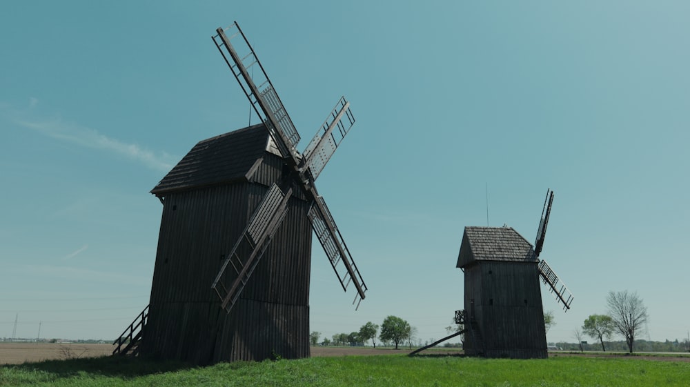 a couple of windmills sitting on top of a lush green field