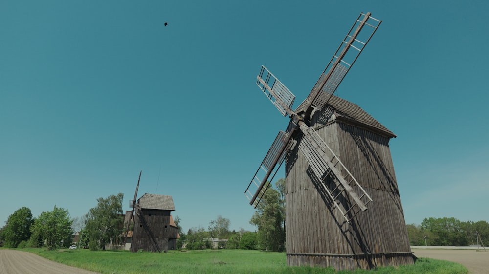 two windmills in a field with a blue sky