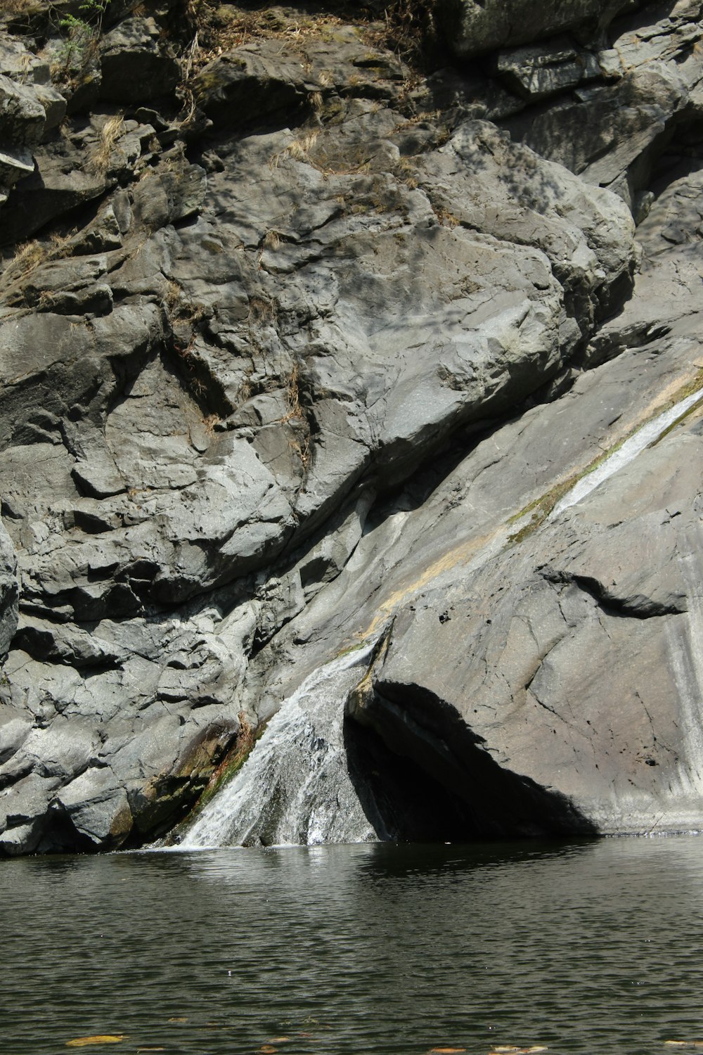 a man standing on a rock next to a body of water