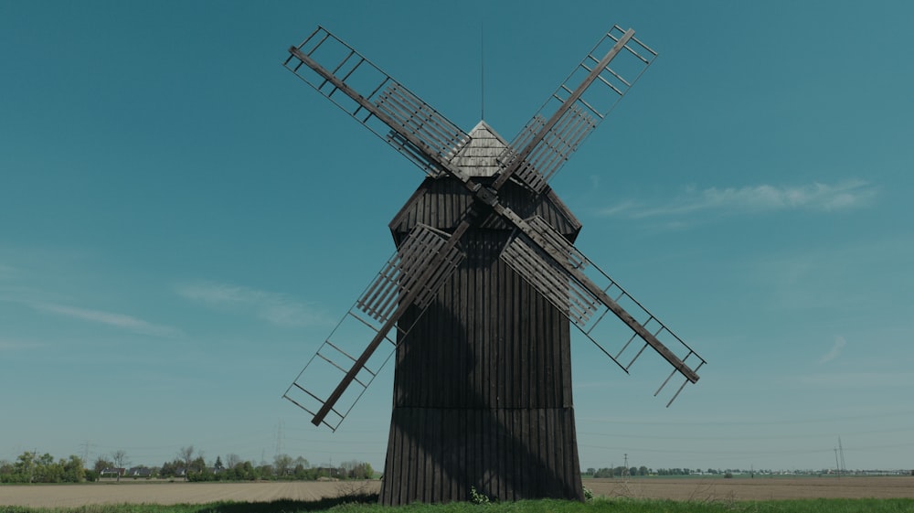 a windmill in a field with a blue sky