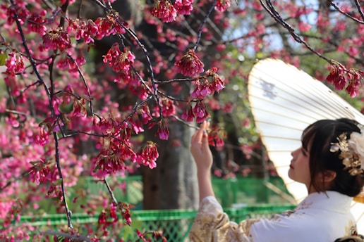 a woman in a kimono is holding an umbrella