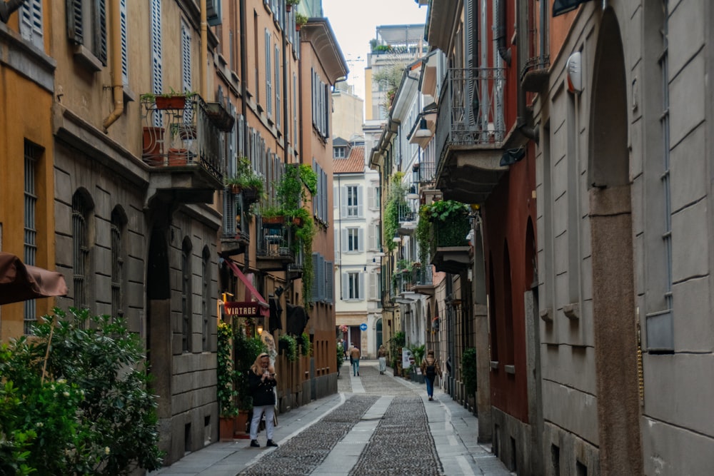 uma rua estreita com pessoas caminhando por ela