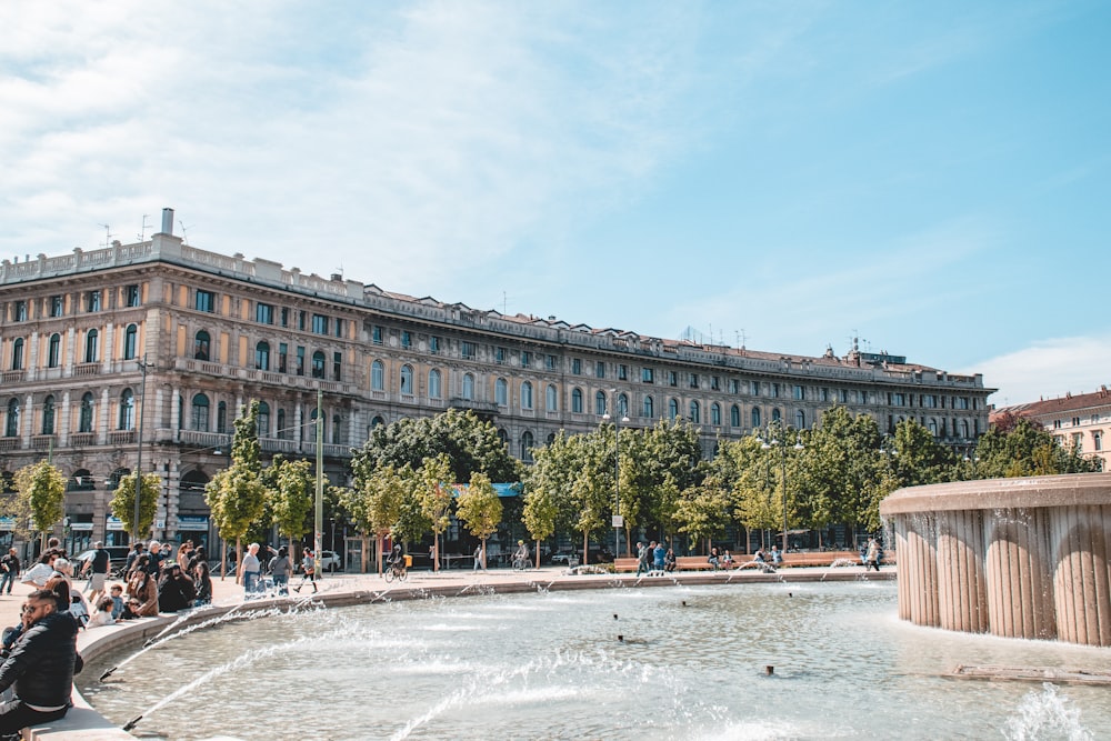 a group of people sitting around a fountain