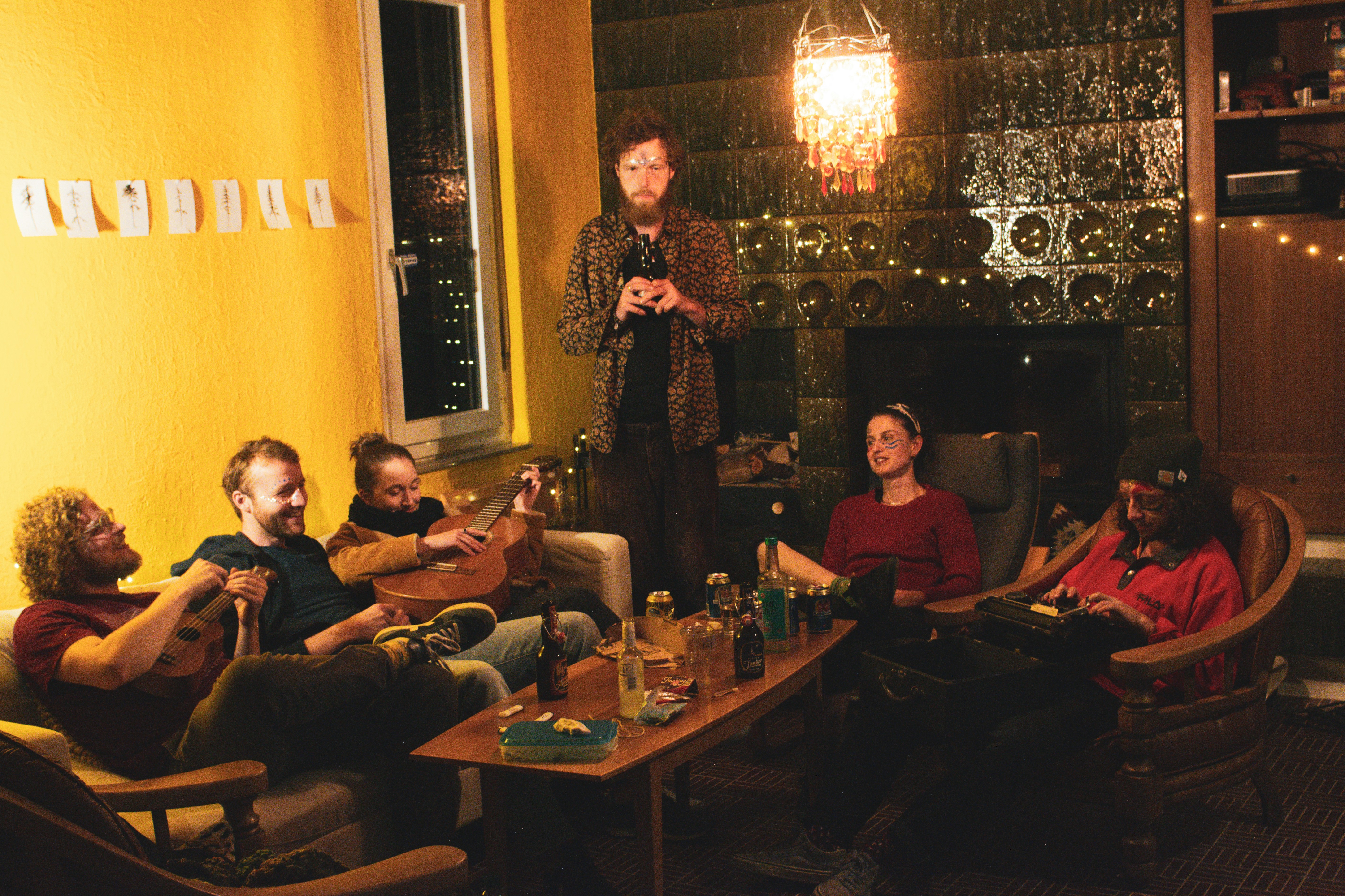 Group of young people playing games together, laughing, dim indoor lighting, dark background, warm candlelight atmosphere