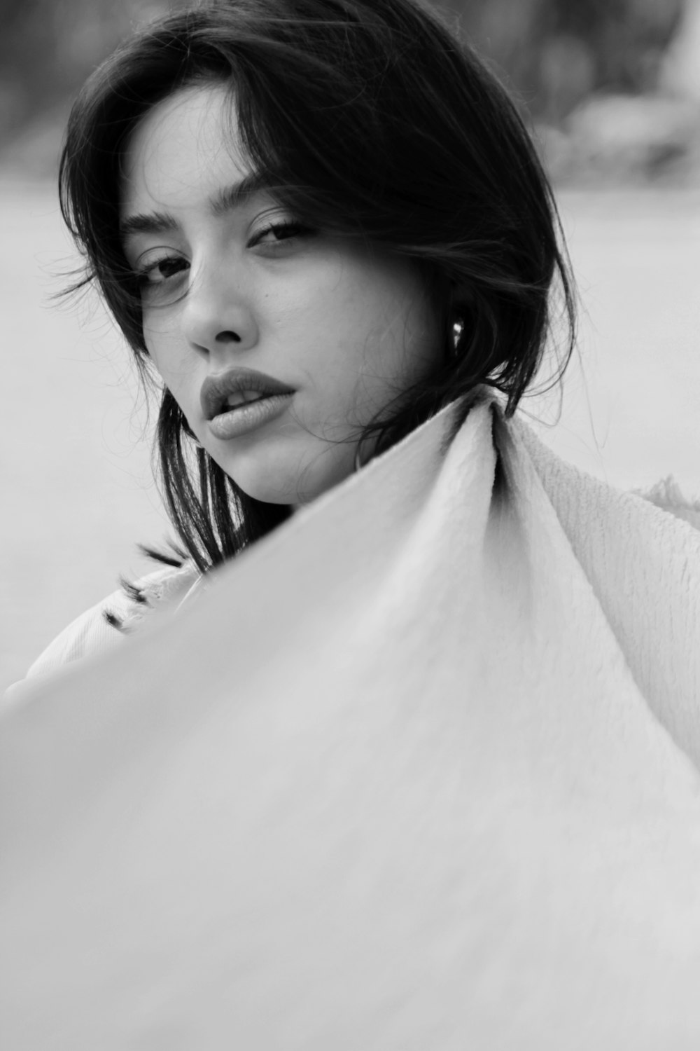 a black and white photo of a woman wrapped in a blanket