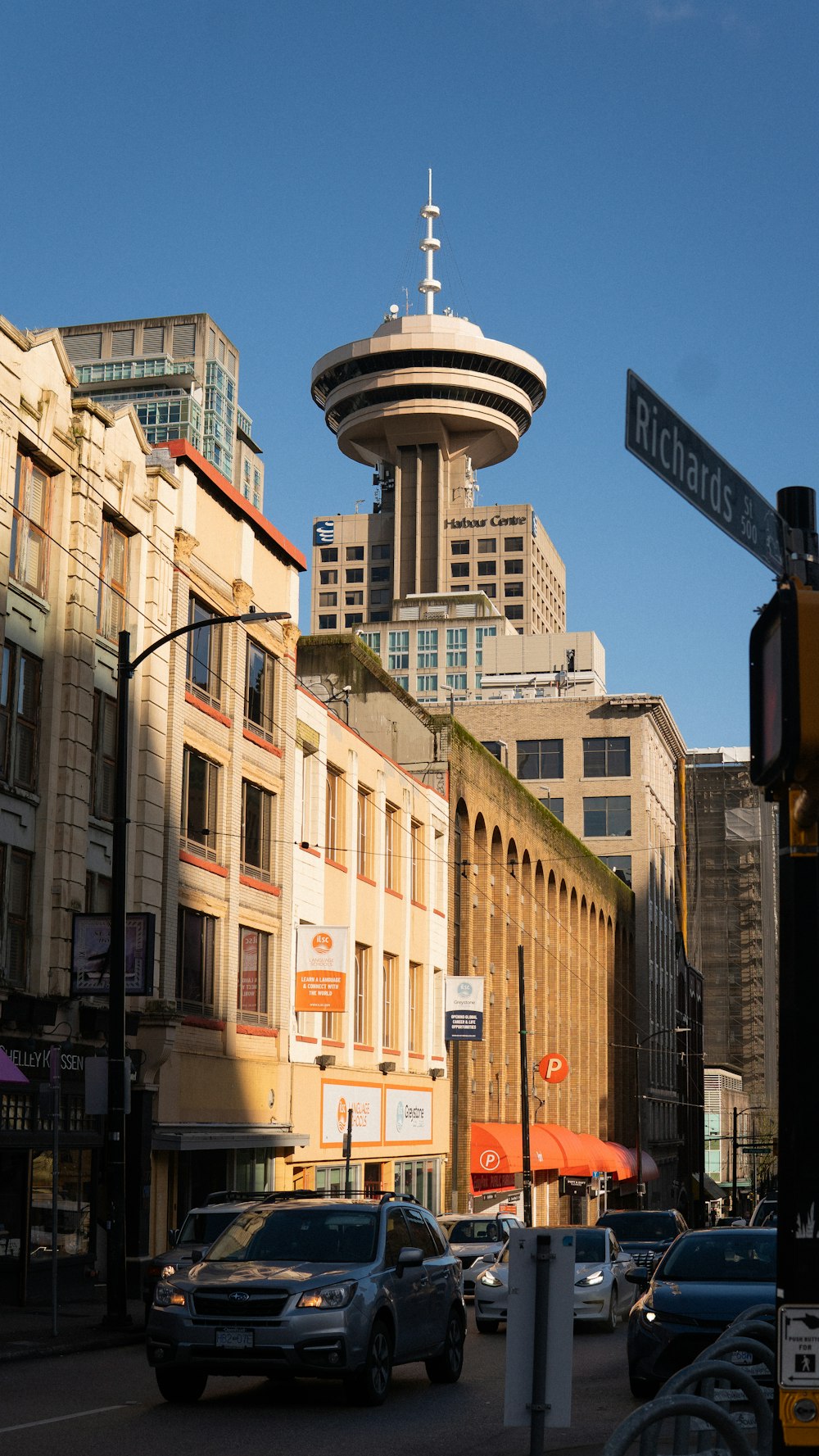 a city street filled with traffic next to tall buildings