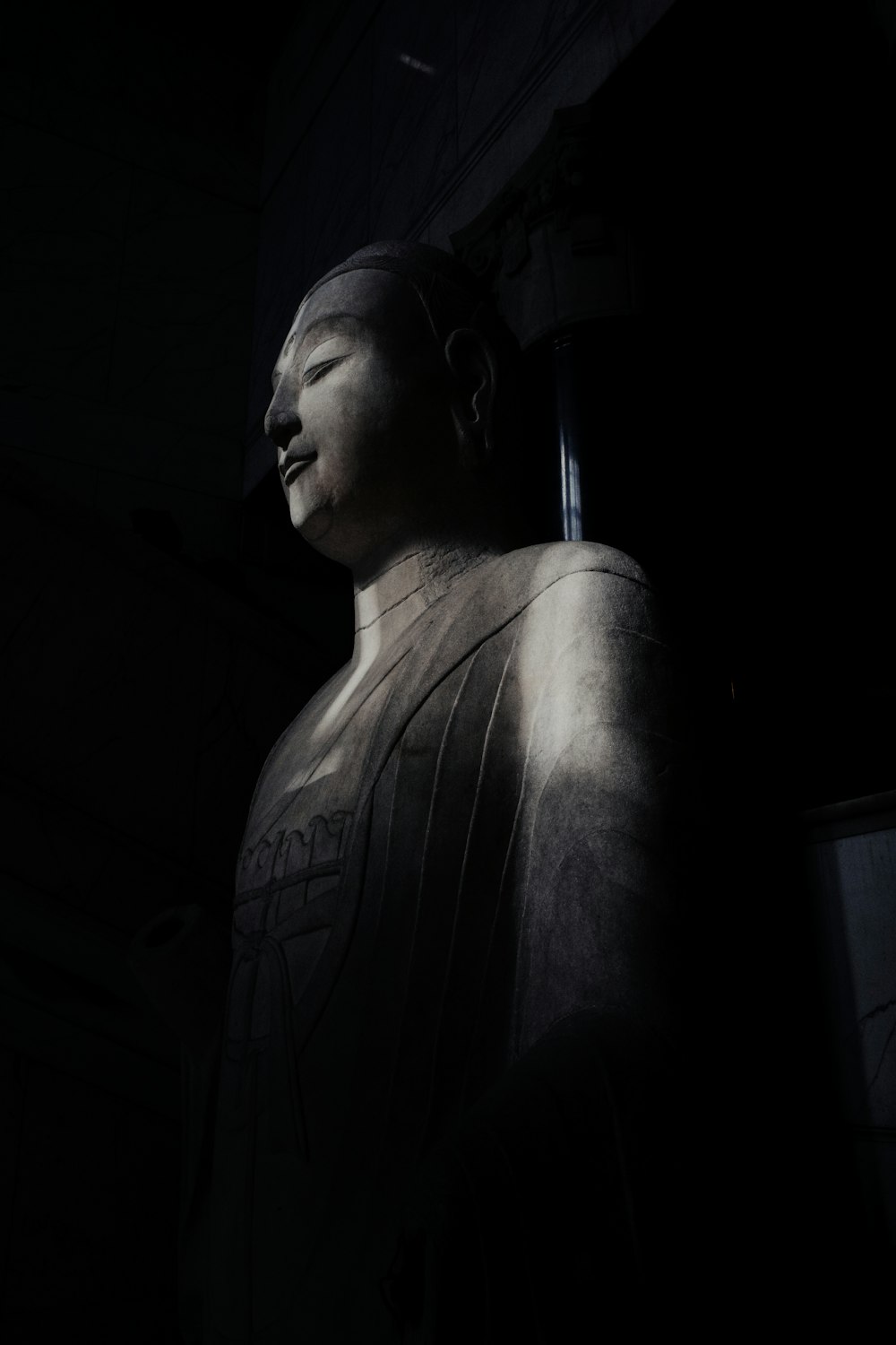 a large statue of a person in a dark room