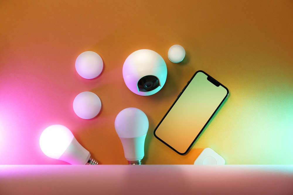 un teléfono celular encima de una mesa junto a bombillas