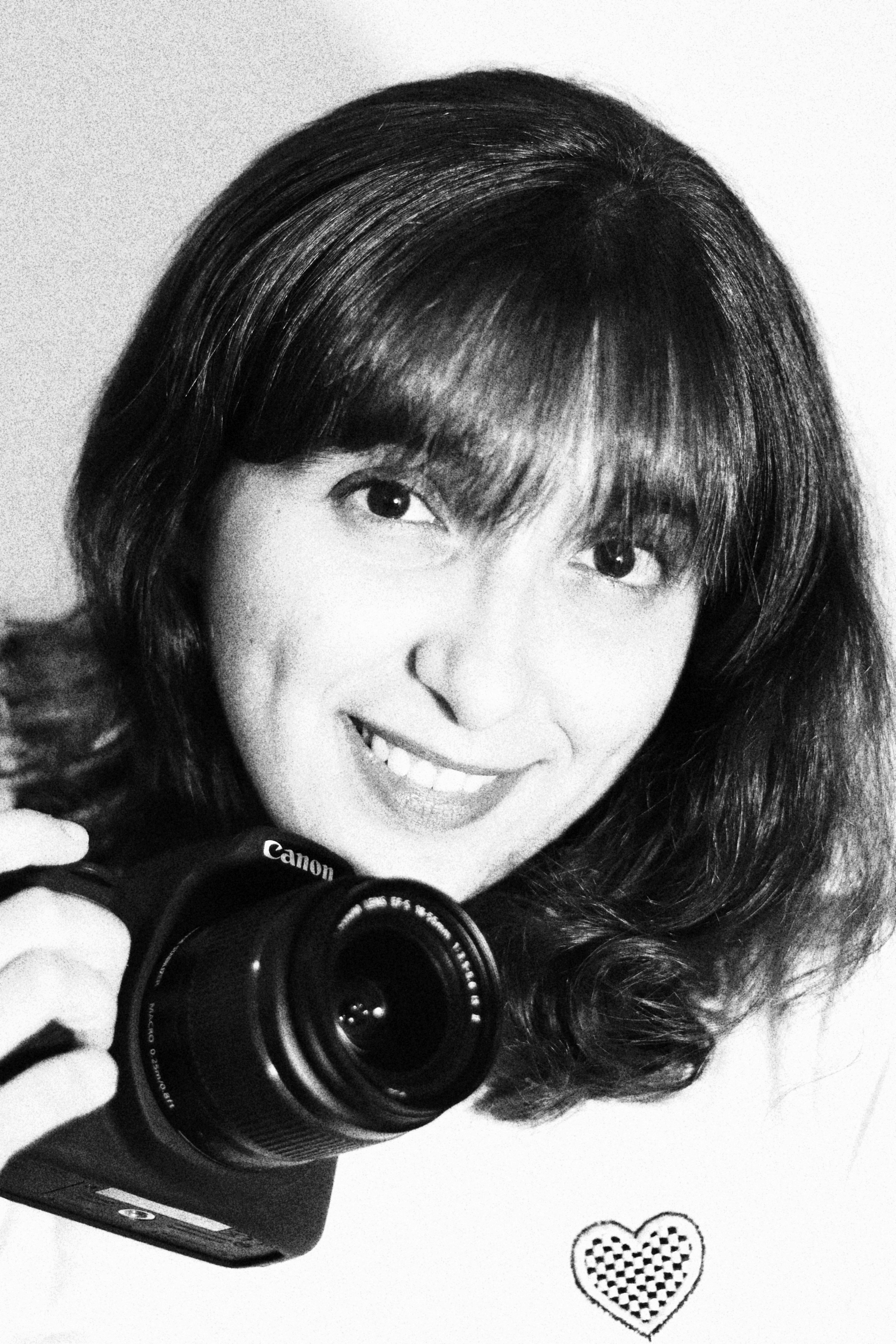 Portrait of Caribbean female photographer Kezia Rampersad smiling with camera