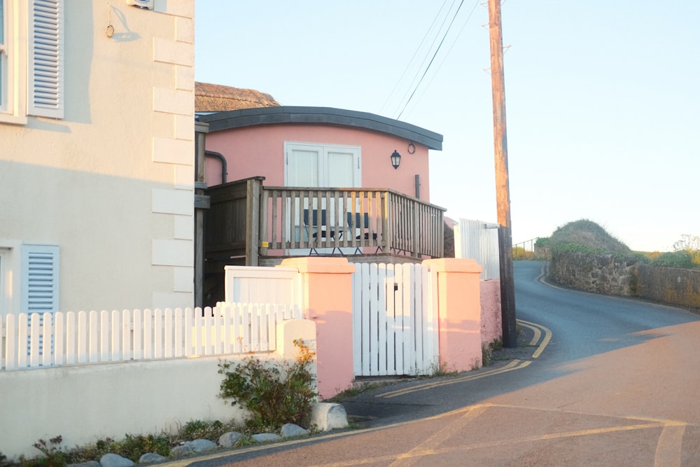 a pink house with a white picket fence