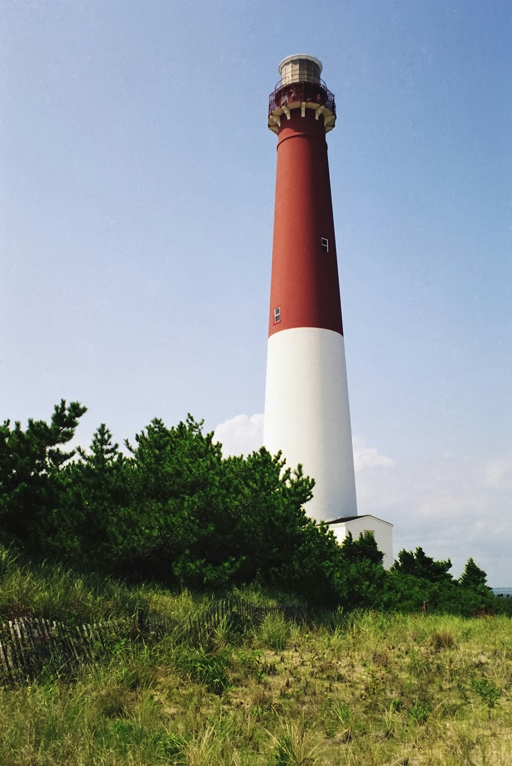 a red and white light house sitting on top of a hill