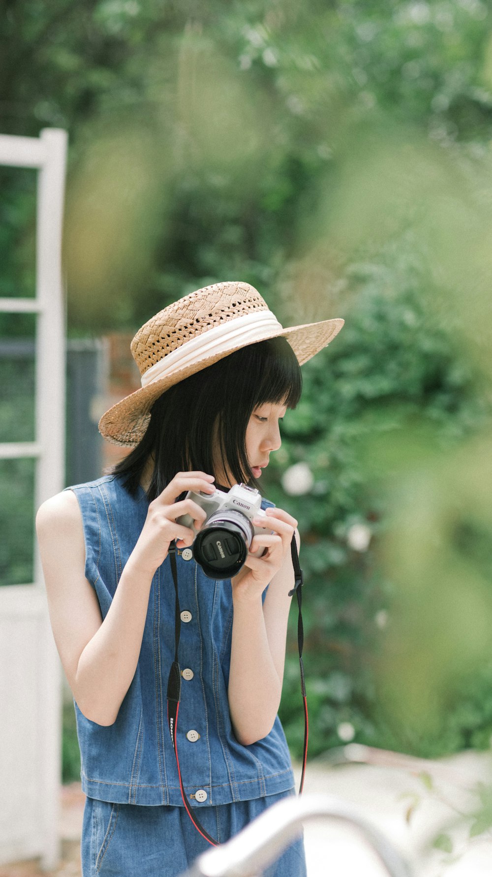 a woman wearing a hat and holding a camera