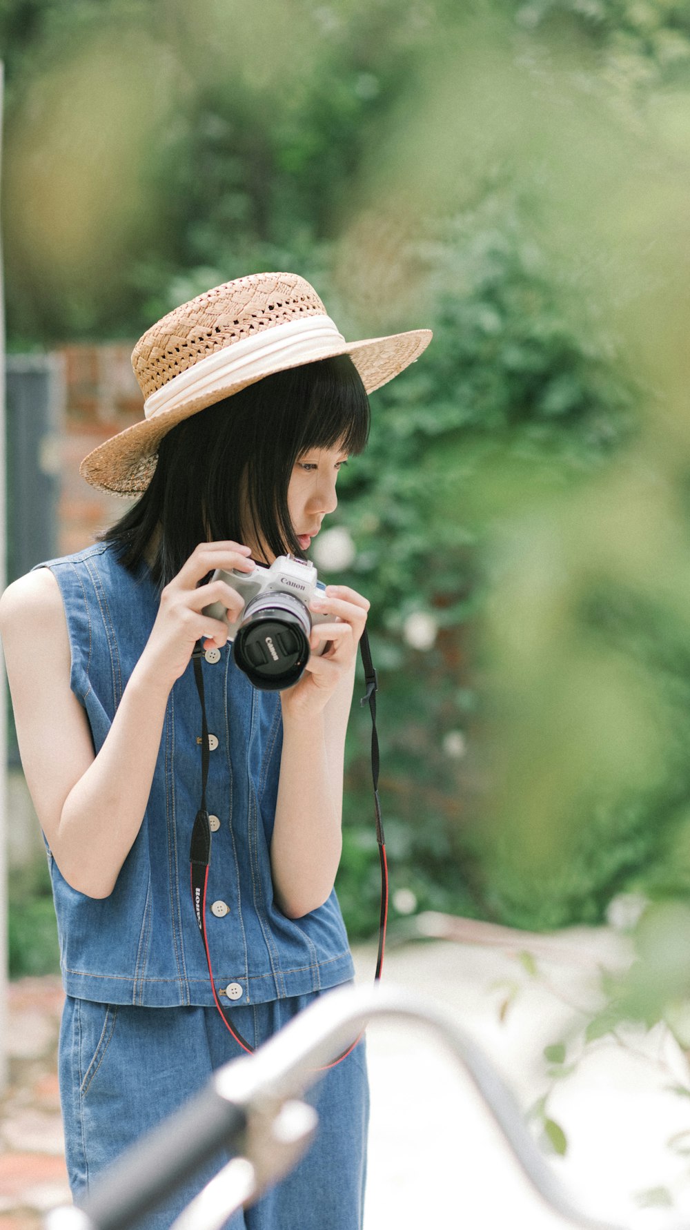 a woman wearing a hat and holding a camera
