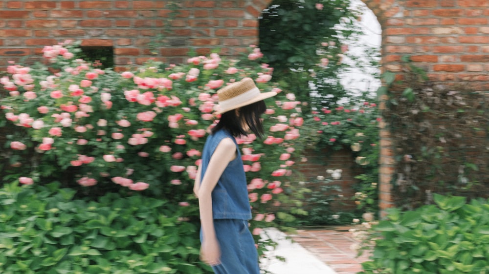 a woman wearing a hat and a blue dress