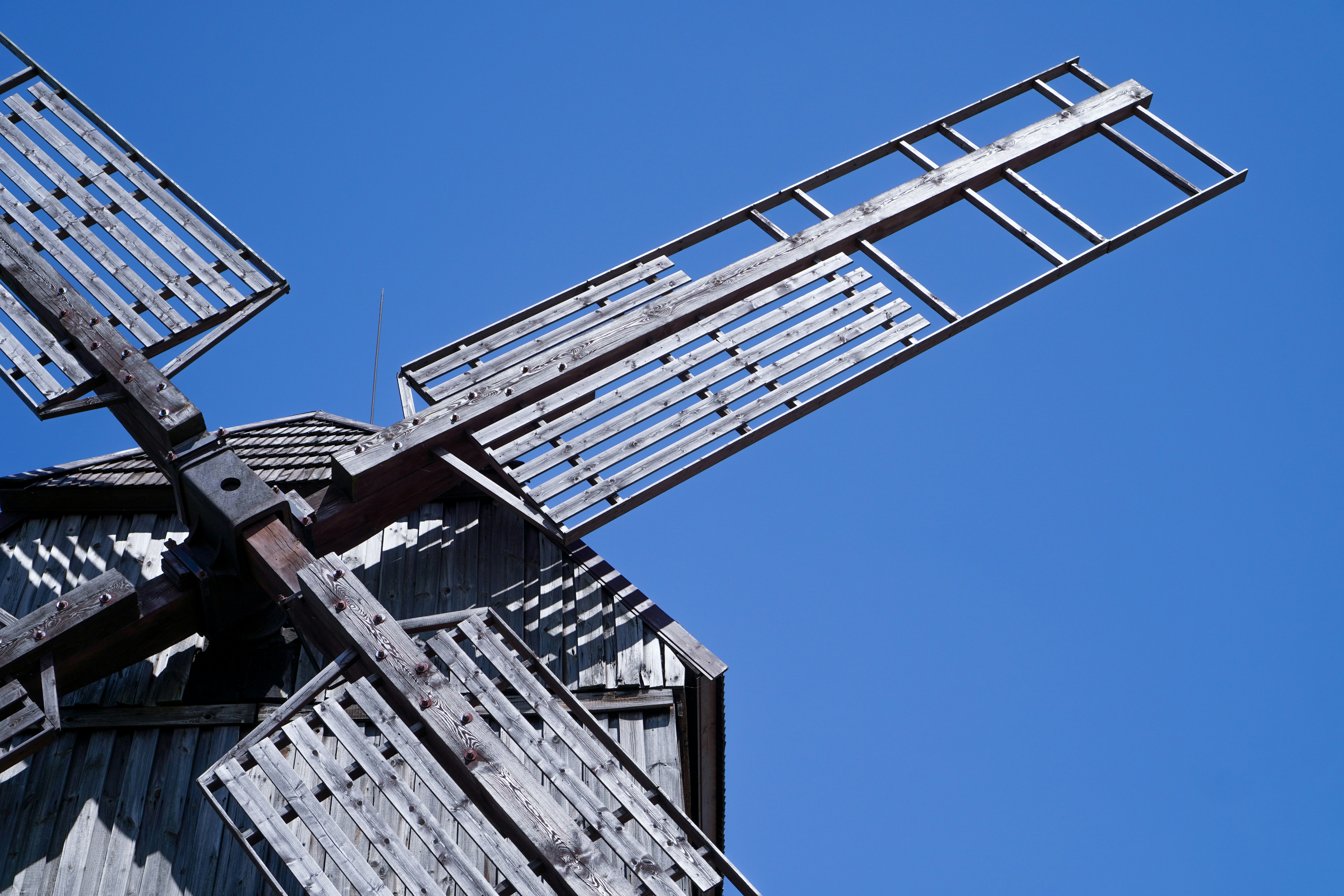un mulino a vento in metallo con un cielo blu sullo sfondo