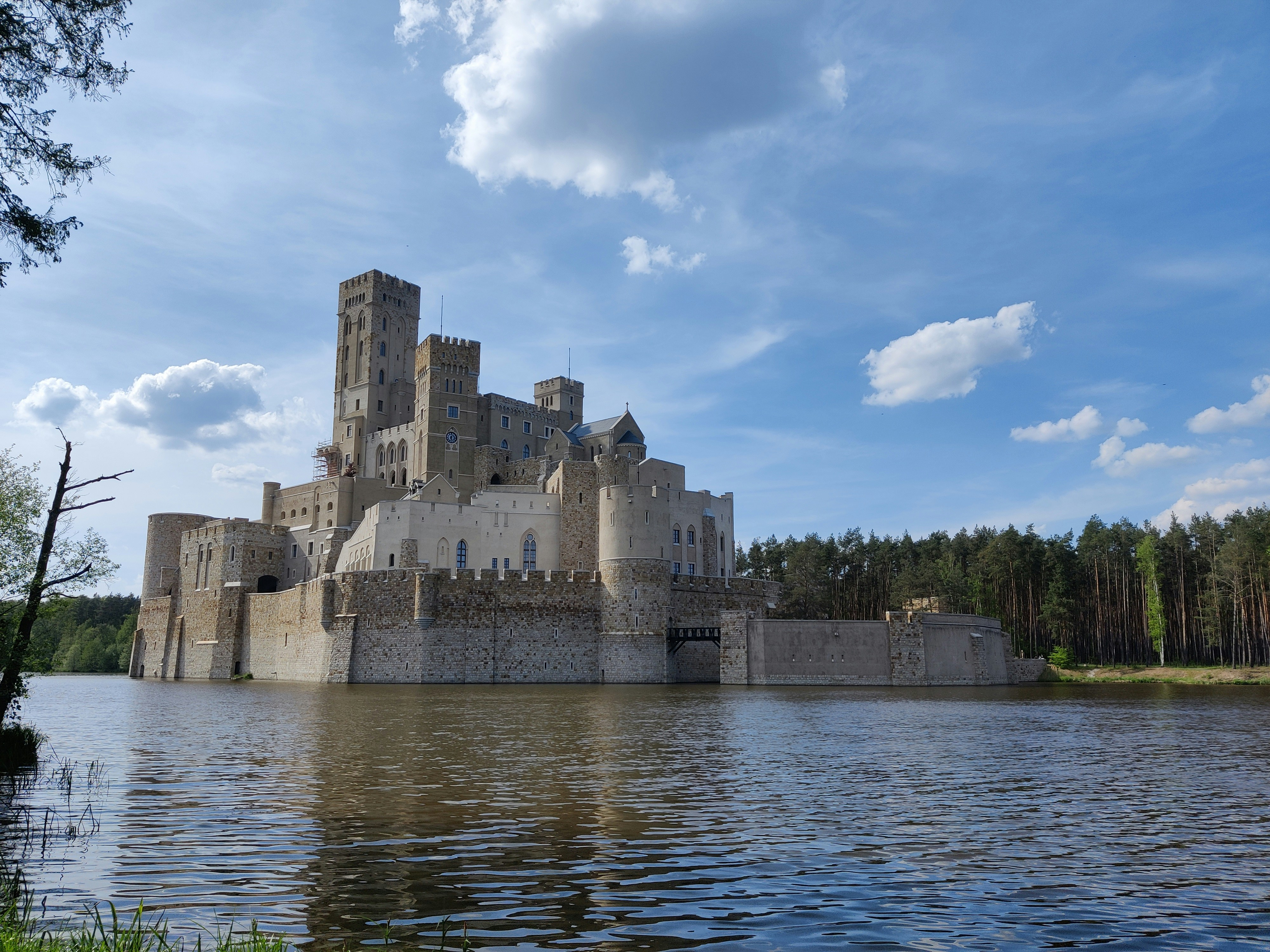 Un castello seduto in cima a un lago vicino a una foresta