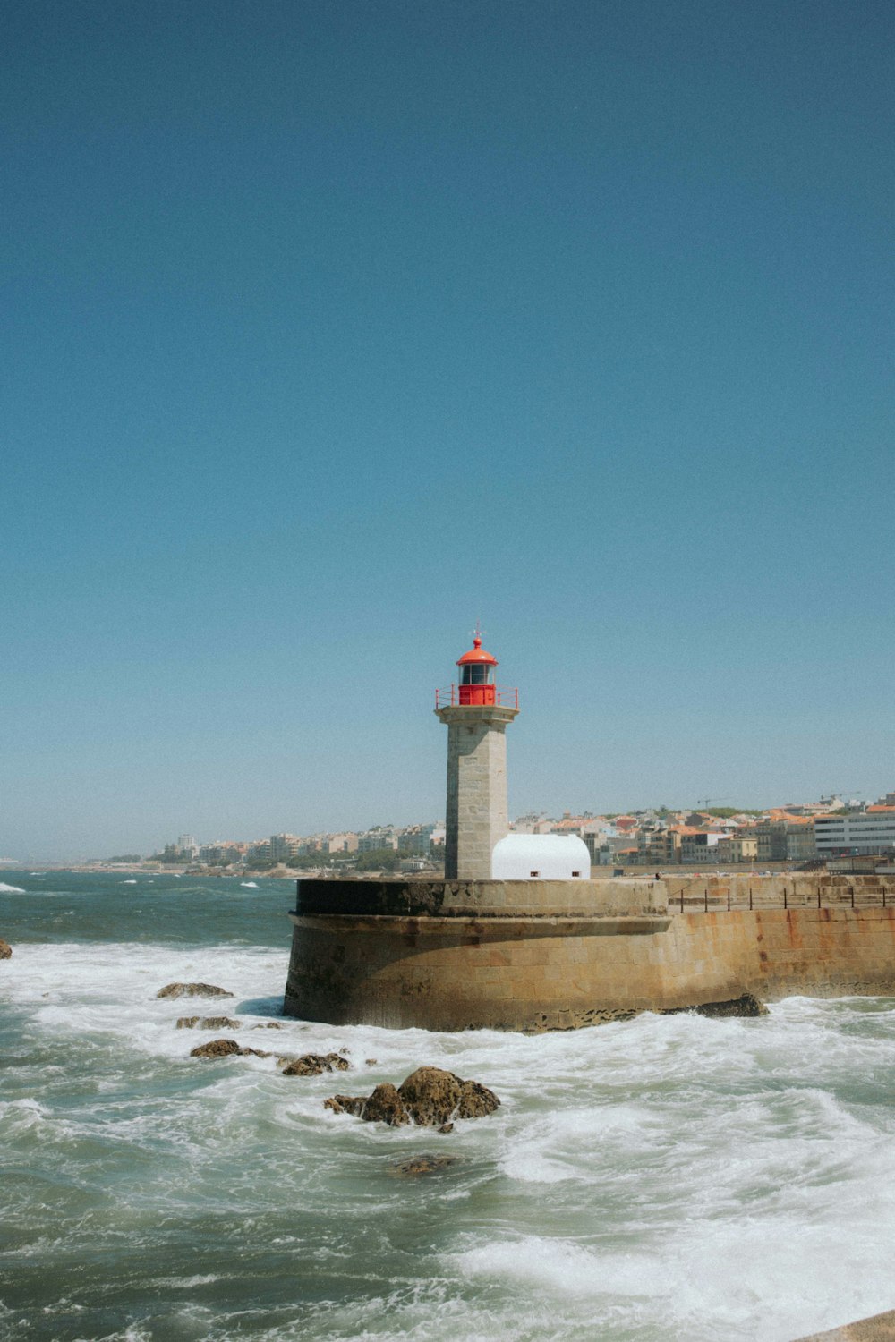 a light house sitting on top of a pier next to the ocean