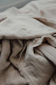 an unmade bed with a blanket on top of it