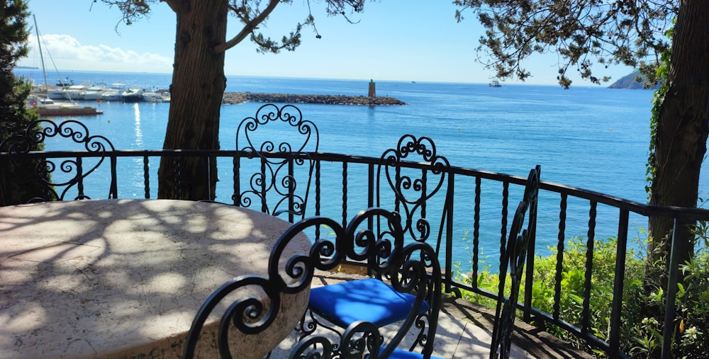 a table and chairs on a balcony overlooking the ocean