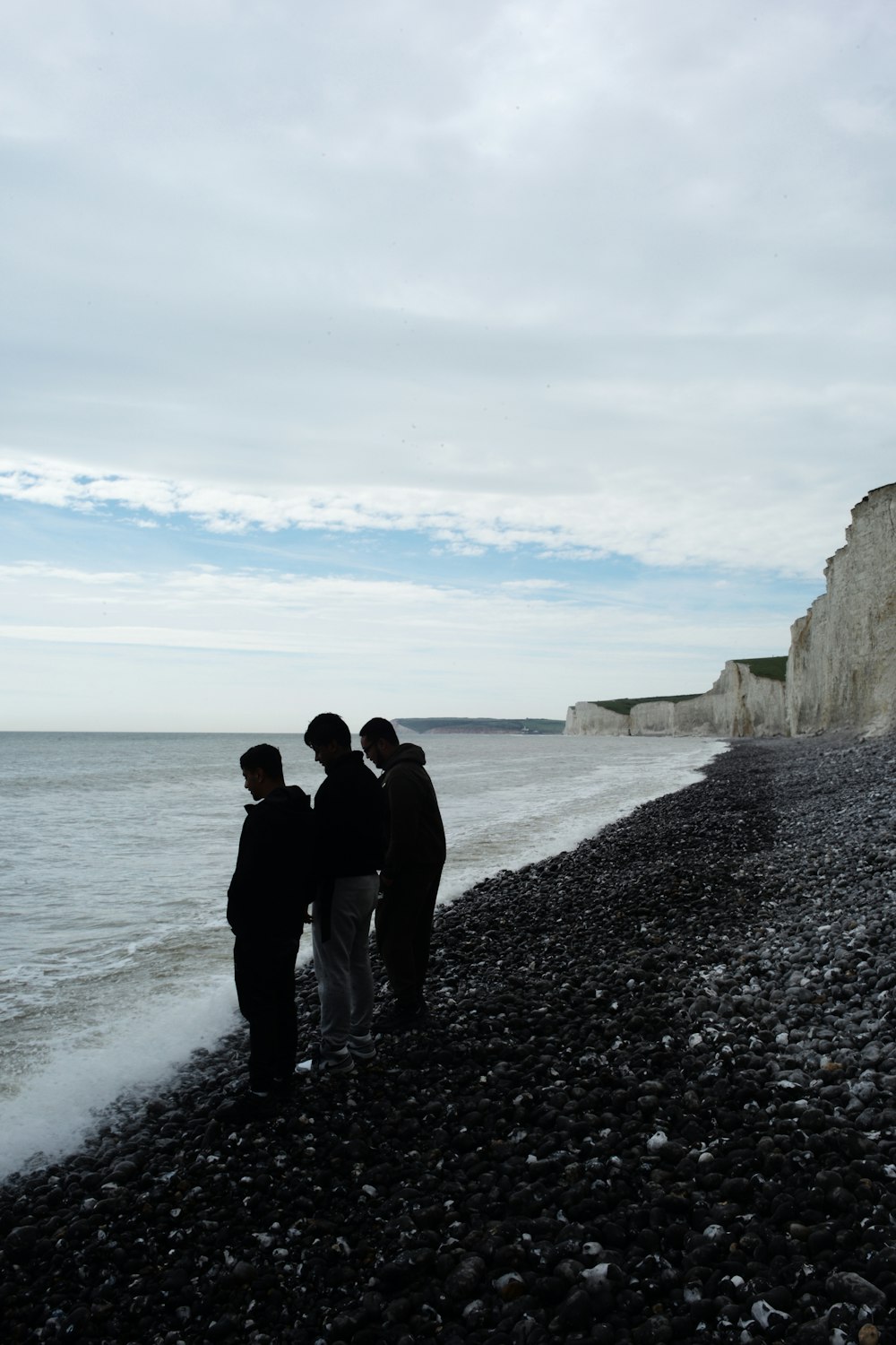 a group of people standing on top of a rocky beach