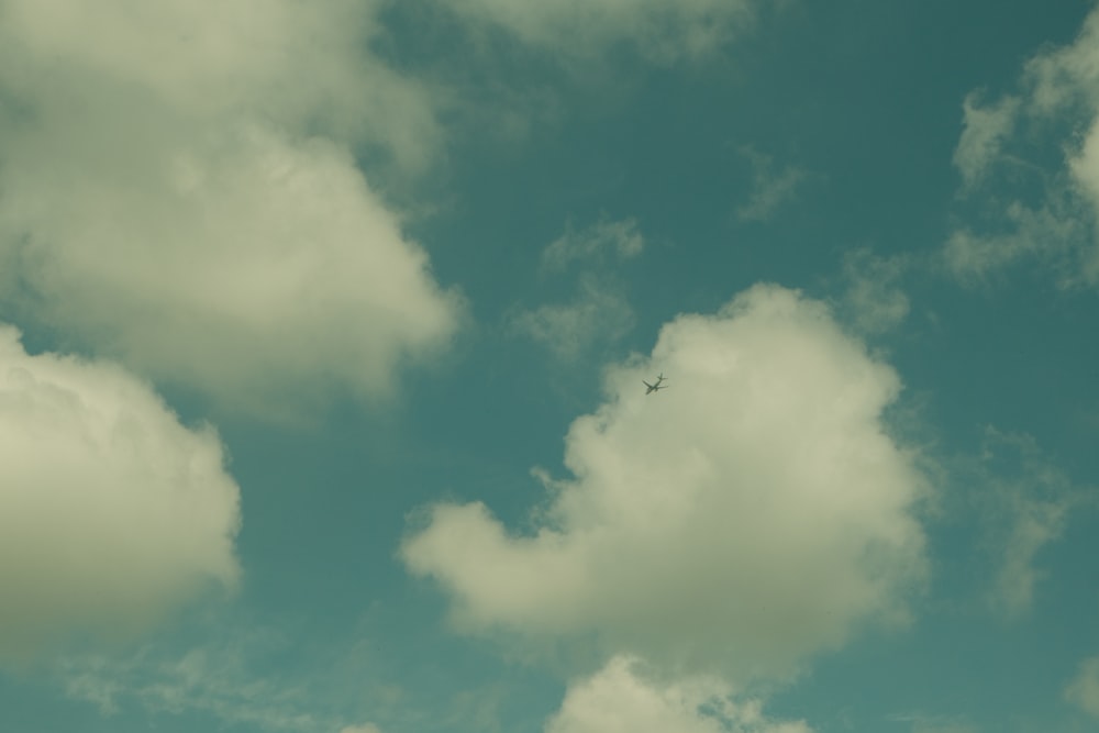 un avión volando a través de un cielo azul nublado
