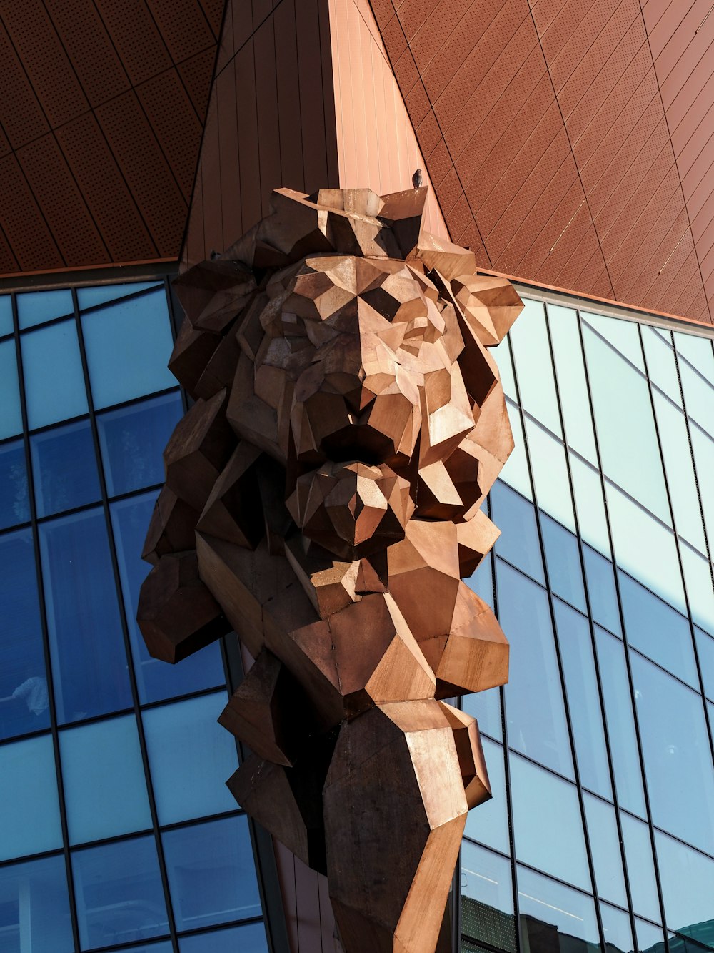 a wooden sculpture of a man holding a surfboard in front of a building