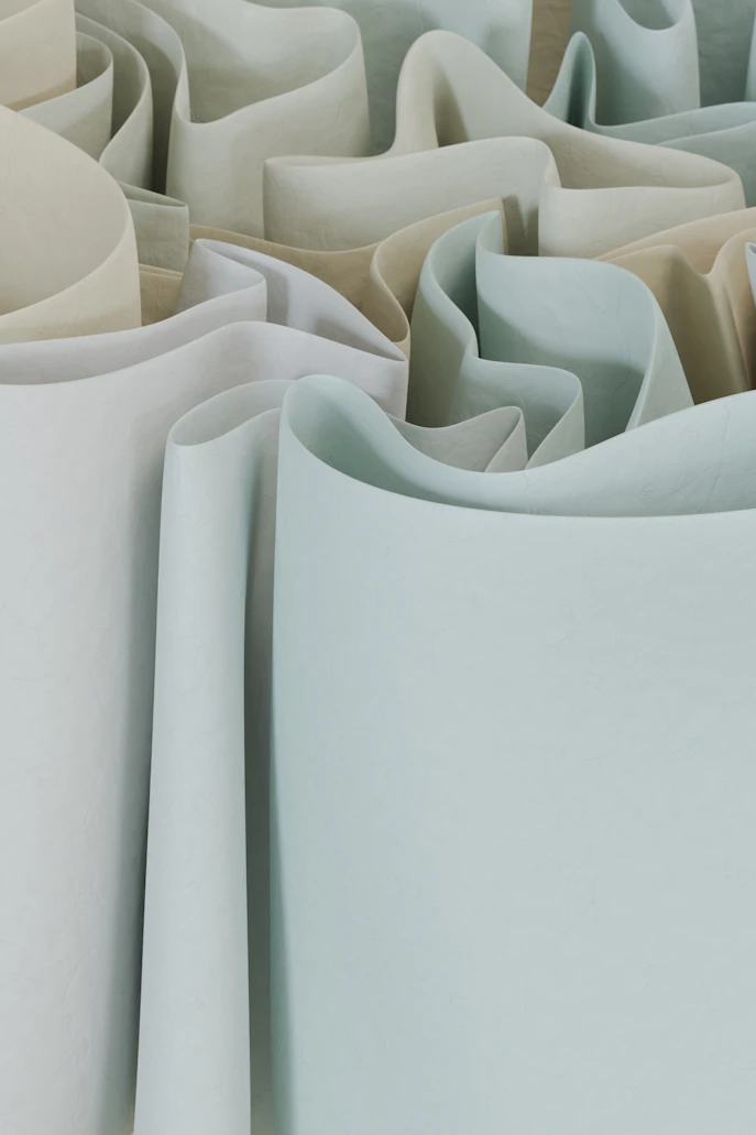 Large commercial rolls of grey and beige fabric