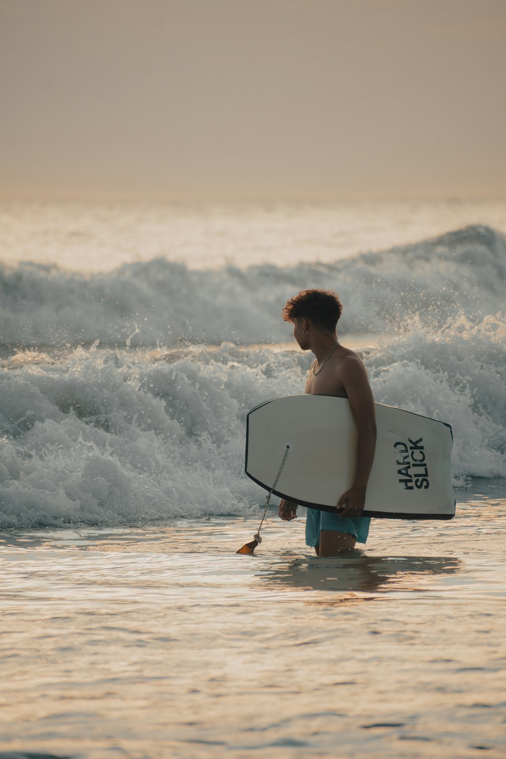 a man holding a surfboard walking into the ocean