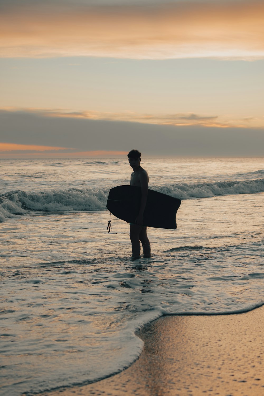 a man holding a surfboard while standing in the ocean