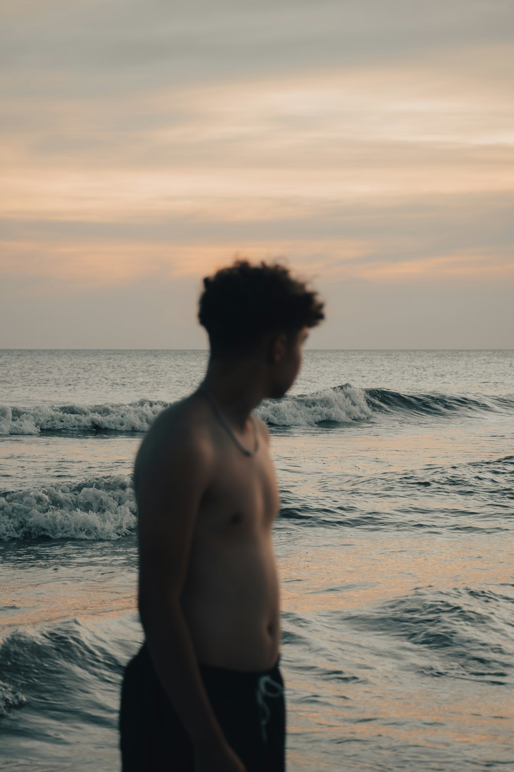 a man standing on a beach next to the ocean