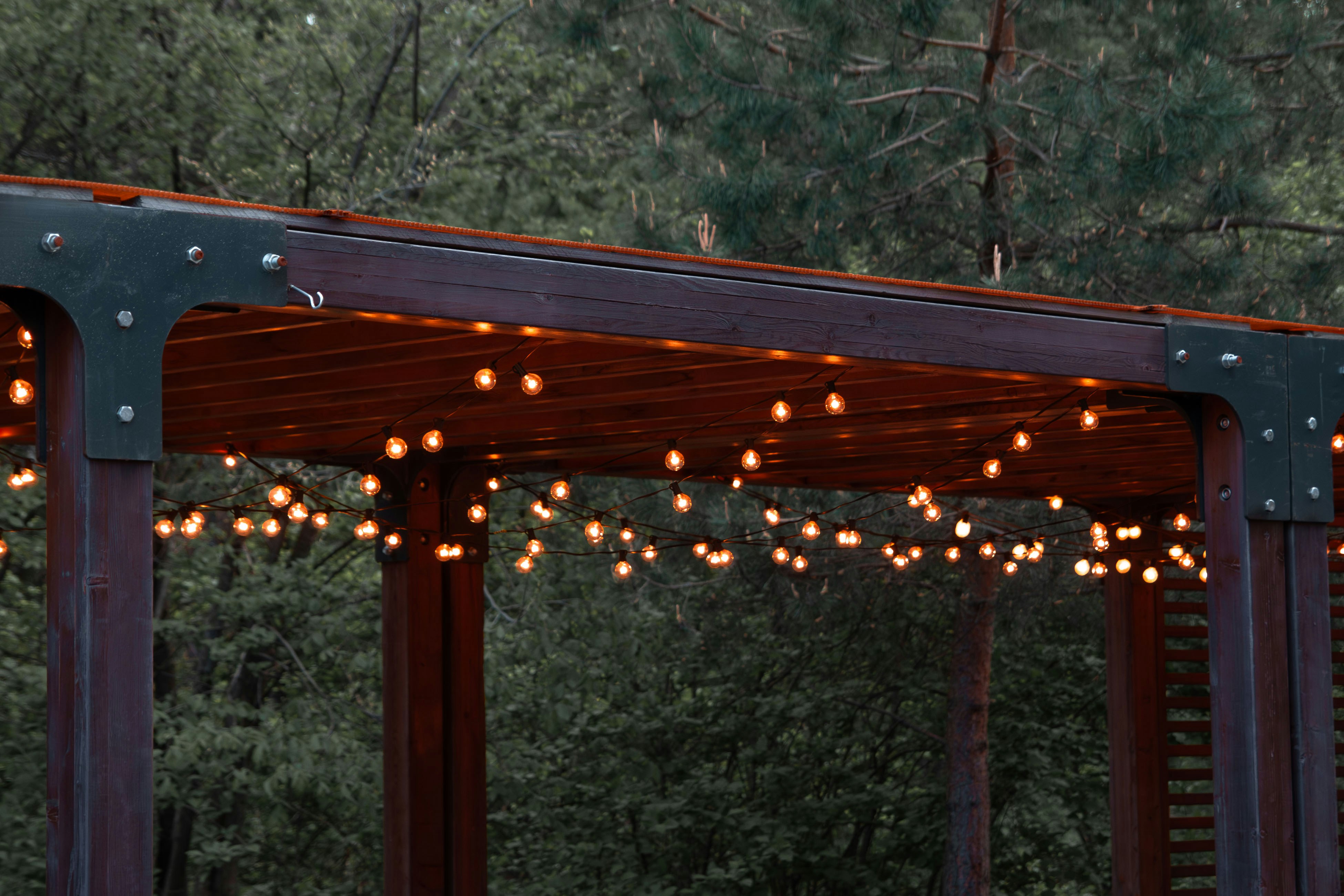 a wooden gazebo with string lights hanging from it
