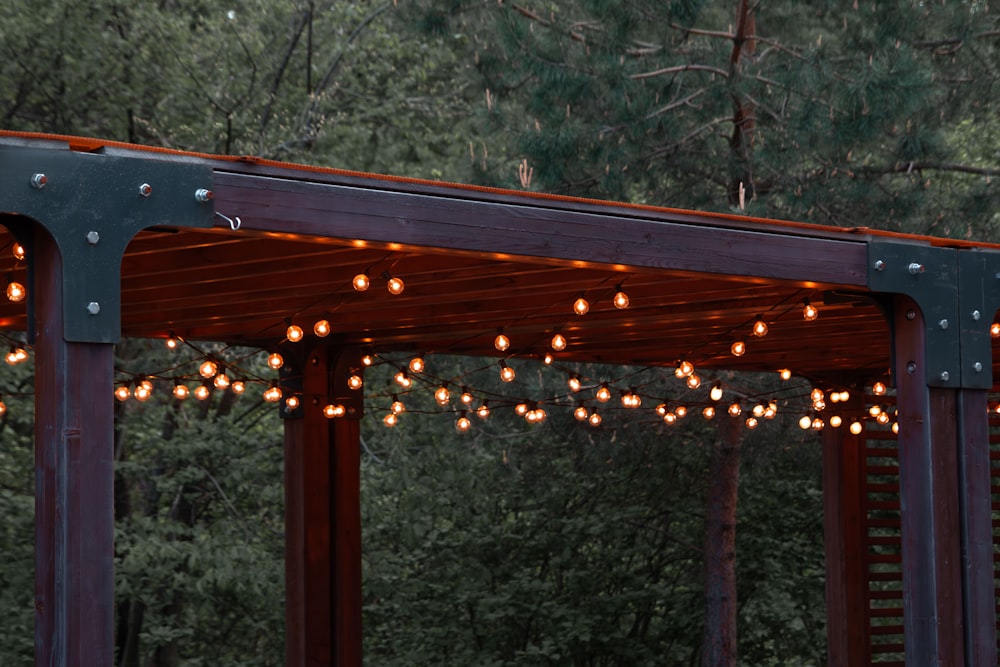 a wooden gazebo with string lights hanging from it