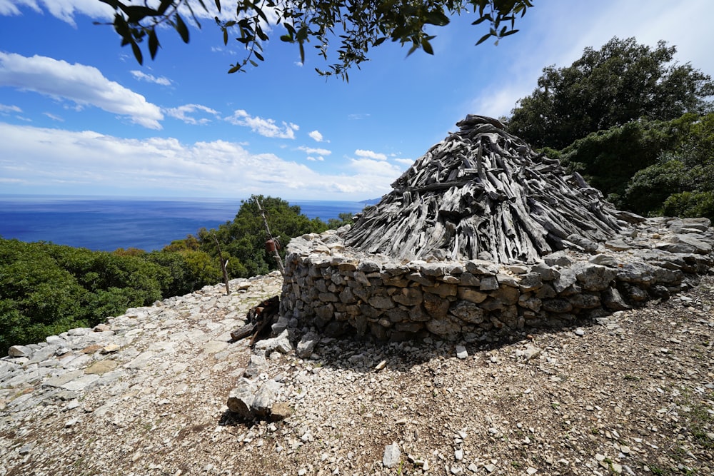 a hut made out of rocks on a hill