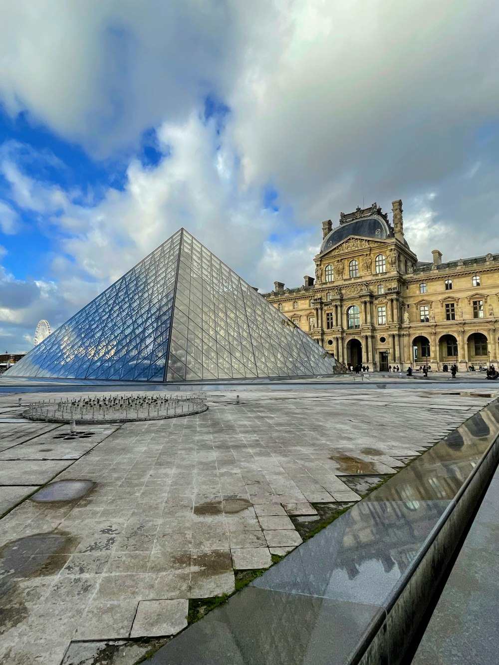 a large glass pyramid sitting in front of a building