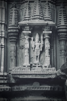a statue of a man holding a sword in front of a building