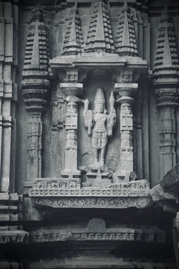 a statue of a man holding a sword in front of a building