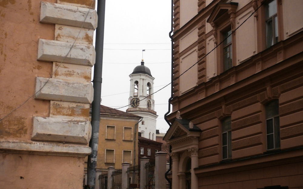 a clock tower in the distance between two buildings