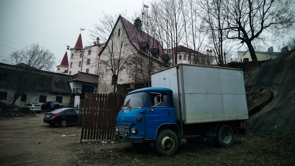 a blue truck parked in front of a house