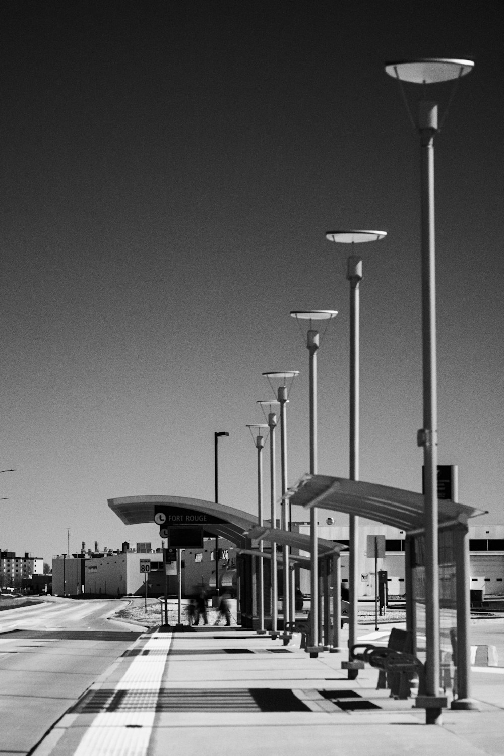 a black and white photo of a bus stop